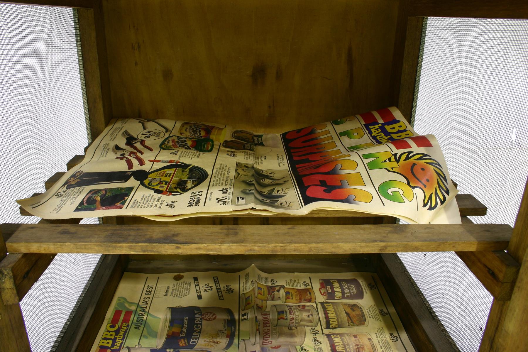 Food Safe - Old Lolly Shop, Carlton North, 1939-1990 - a wooden shelf with a bunch of magazines