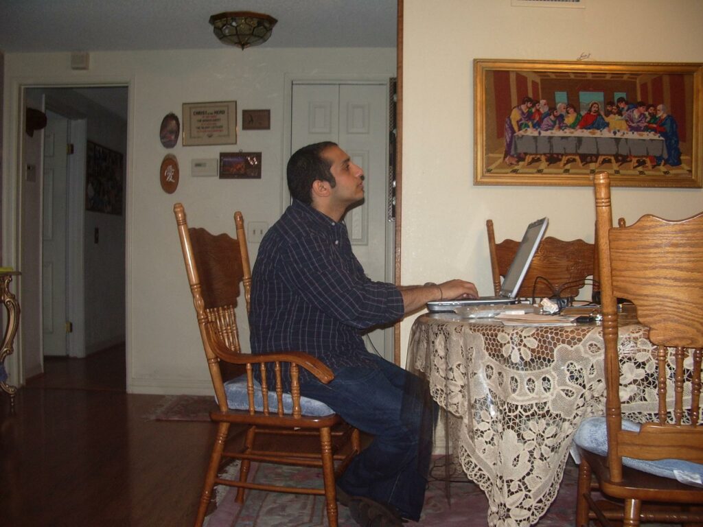 Watching and Blogging - a man sitting at a table with a laptop